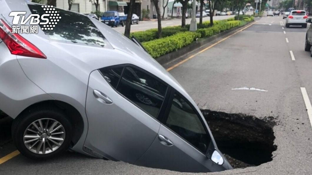 台中大里驚現「天坑」,一輛轎車「倒頭栽」掉進洞內。(圖/警方提供)