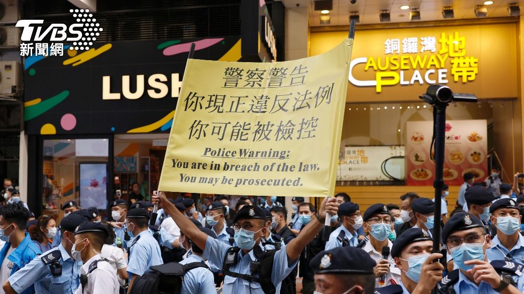 香港警方於街頭高舉布條,警告示威群眾恐違法。(圖/達志影像路透社)
