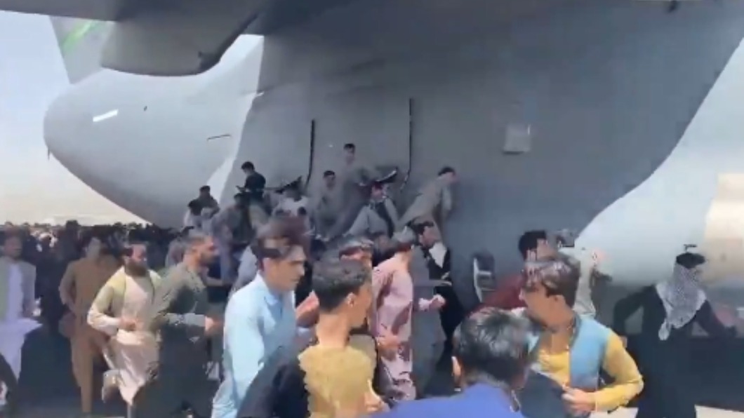 逾10人不顧性命爬上飛機,就為了逃離當地。(圖/翻攝自@AsvakaNews推特)