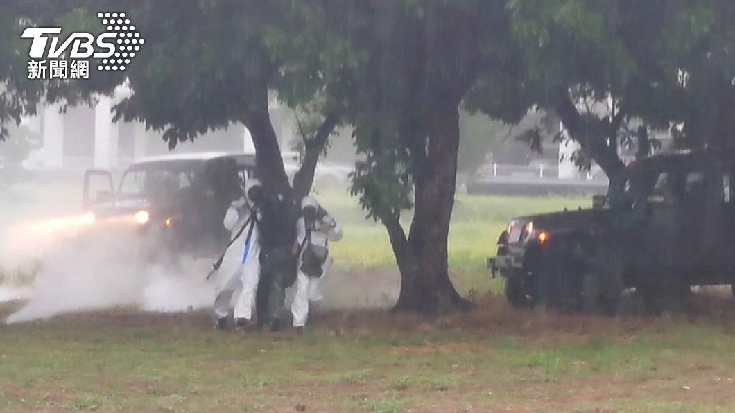 身著防護衣的化學兵模擬搶救疑似受生化武器攻擊受傷的官兵。（圖／中央社）