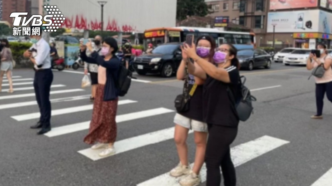 台中出現懸日美景,民眾過馬路也不放過,紛紛拿起手機拍攝。(圖/警方提供)