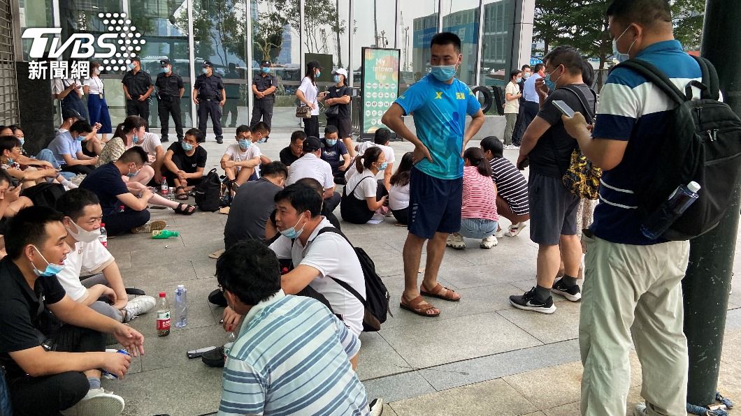 投資人席地坐在恆大辦公大樓外。(圖/達志影像路透社)