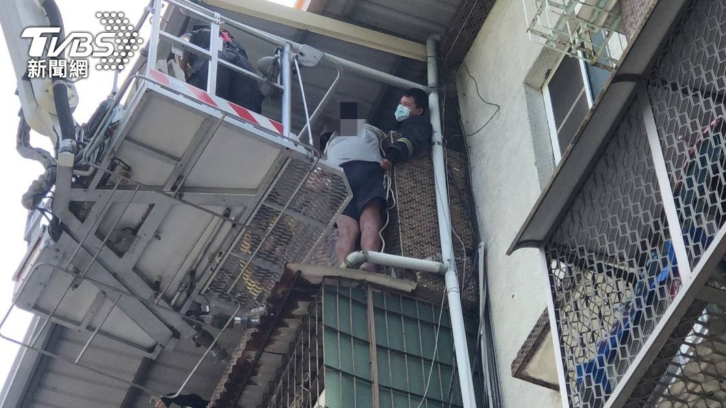 高雄一名男子為撿10元，受困5樓公寓的遮雨棚上，消防出動雲梯車將人救出。（圖／消防提供）