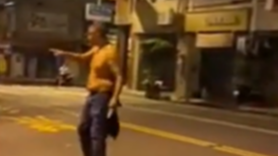 外籍男手持雙刀,從騎樓大鬧至馬路上。(圖/翻攝自網路)