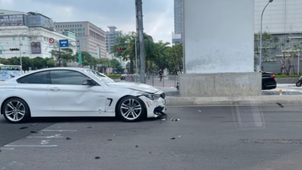 白色BMW疑似違規左轉,導致2騎士接連重摔倒地。(圖/翻攝自記者爆料網)