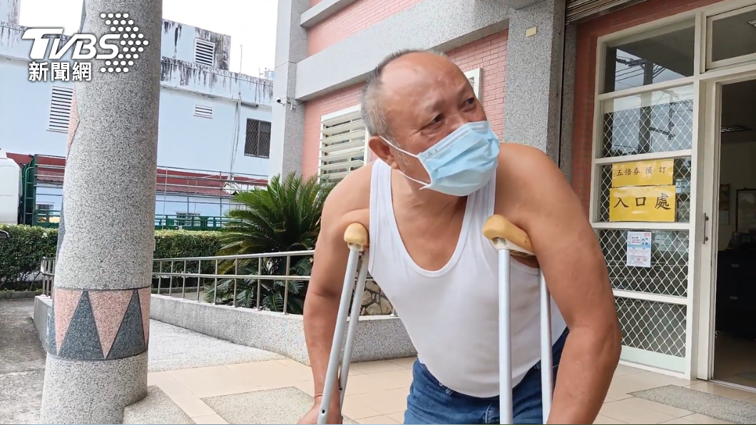 民眾拄拐杖預訂五倍券,因人太多又先行離開。(圖/TVBS)