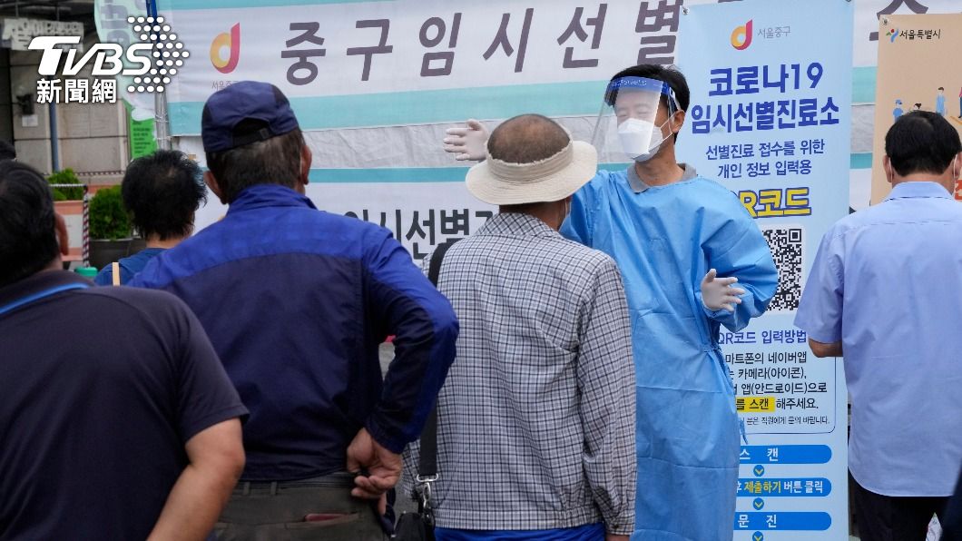 篩檢站人潮眾多,醫護人員引導民眾排隊。(圖/AP)