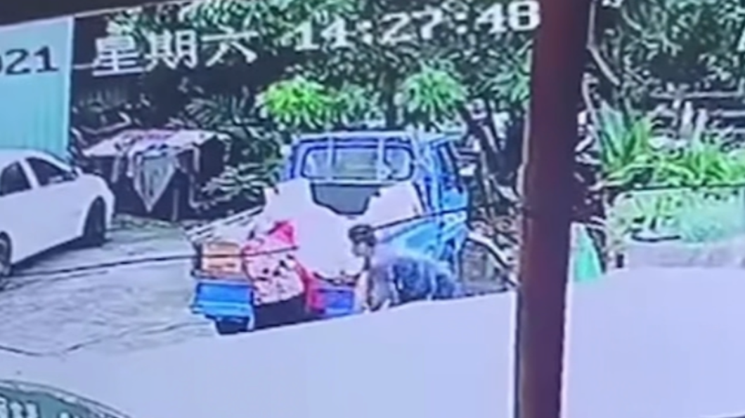 林婦正在整理物資突遭棍棒毆打。(圖/翻攝自爆料公社(官方粉專專屬))