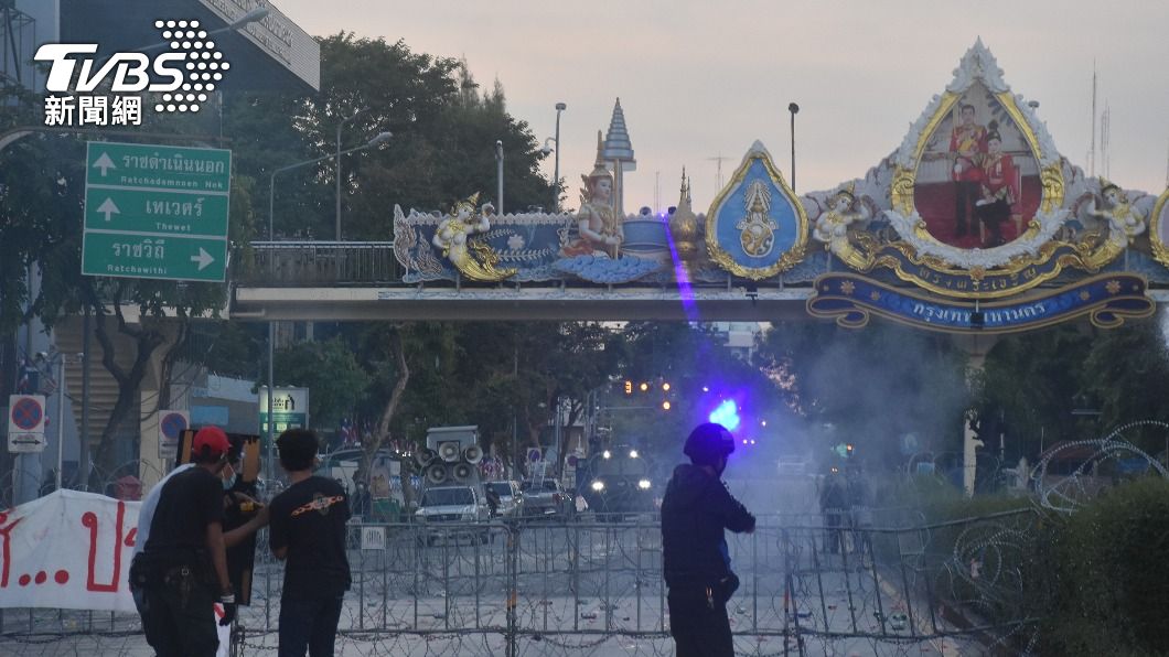 反政府示威人士遭鐵絲網阻擋去路，警察以雷射筆瞄準抗議者所在位置。（圖／中央社）