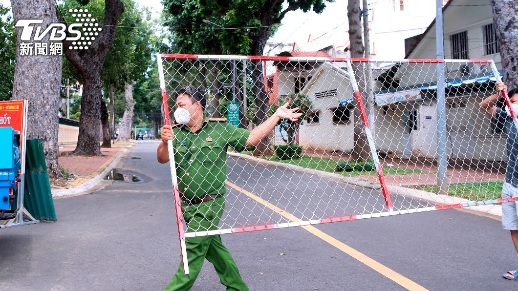 政府宣布解封,越南警方撤掉道路柵欄。(圖/達志影像美聯社)