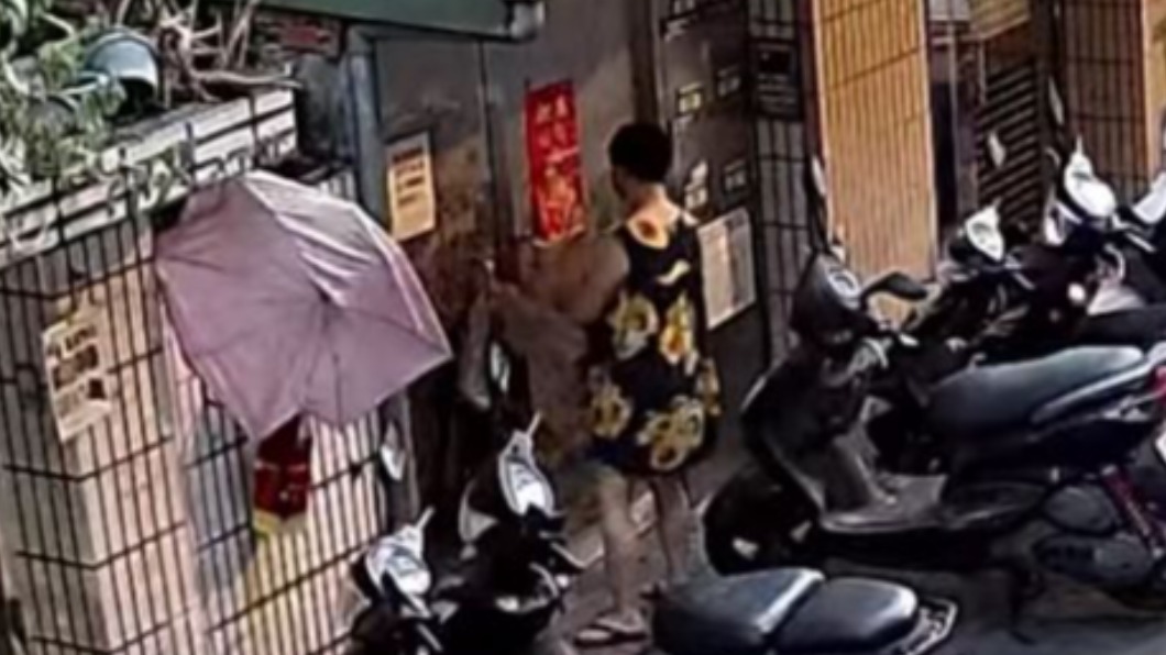 監視器拍下婦人拿出垃圾綑綁公寓大門。（圖／翻攝自我是永和人 臉書）