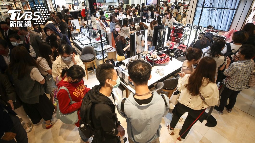 民眾到化妝品專櫃排隊購買獨家特惠商品。(圖/中央社)
