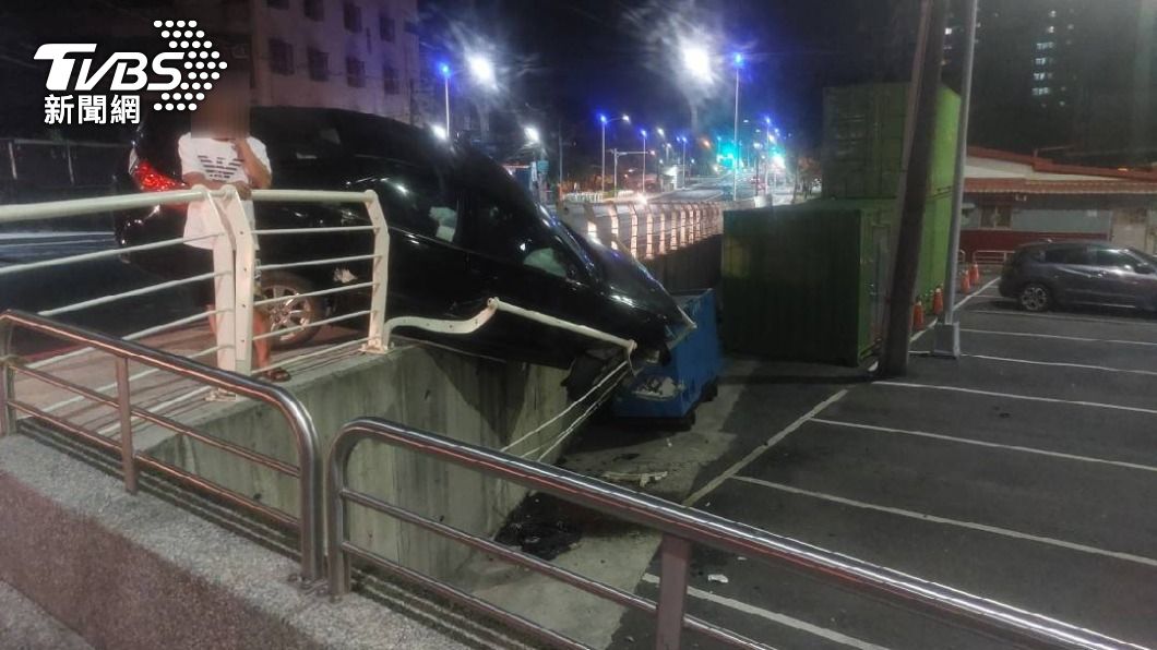 黑色轎車失控「斜插30度」卡護欄,險掉落2公尺高停車場。(圖/警方提供)