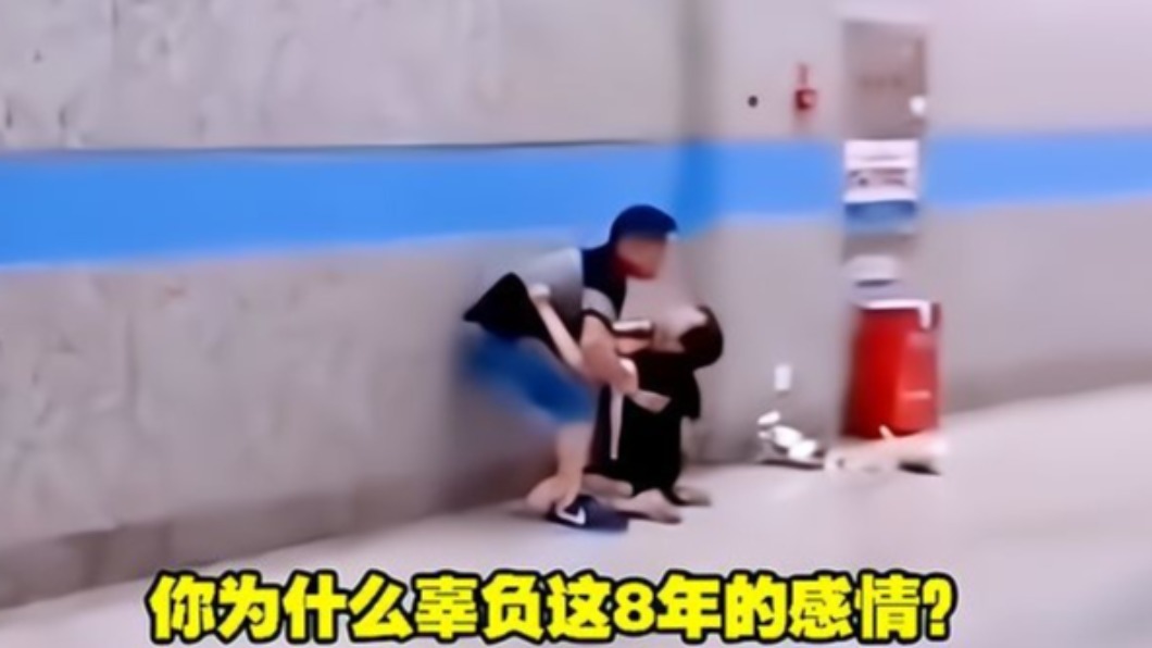 女生緊抓住男生,在大眾面前嚎啕大哭問「你為什麼辜負這8年的感情」。(圖/翻攝自《網易新聞》)