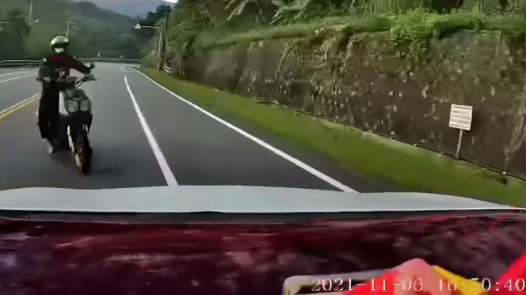 機車騎士「翹孤輪」後衝入對向車道,女乘客嚇死狂尖叫。(圖/翻攝自「爆廢公社公開版」臉書)