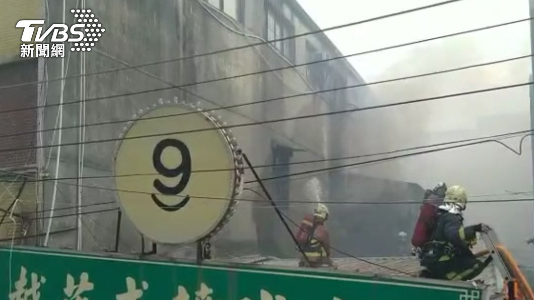 消防人員爬上屋頂灑水。(圖/TVBS)