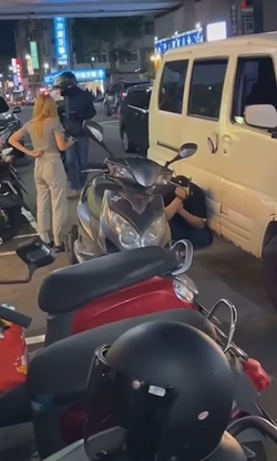 汽車駕駛被噴辣椒水,痛到蹲在路邊。(圖/翻攝自爆廢公社)