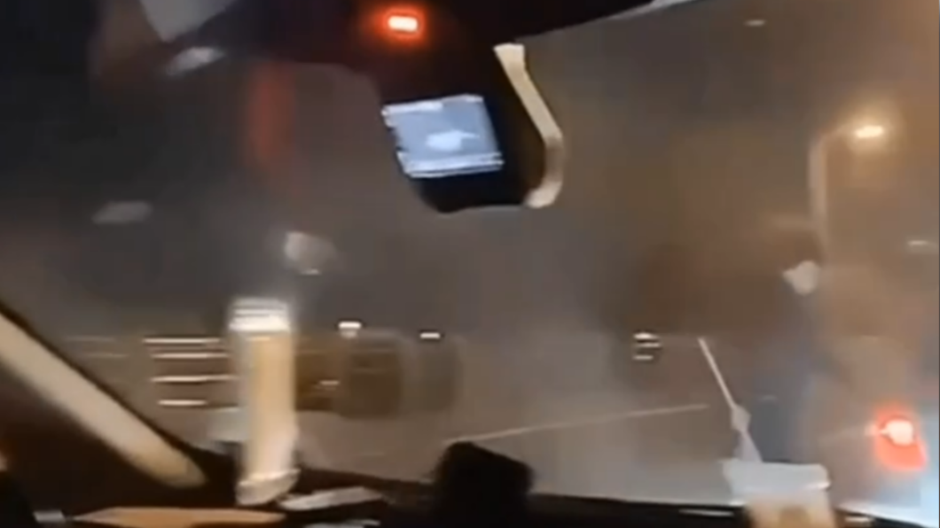 掃把男被噴霧狂襲,躲回車內。(圖/翻攝自中部版記者爆料網)