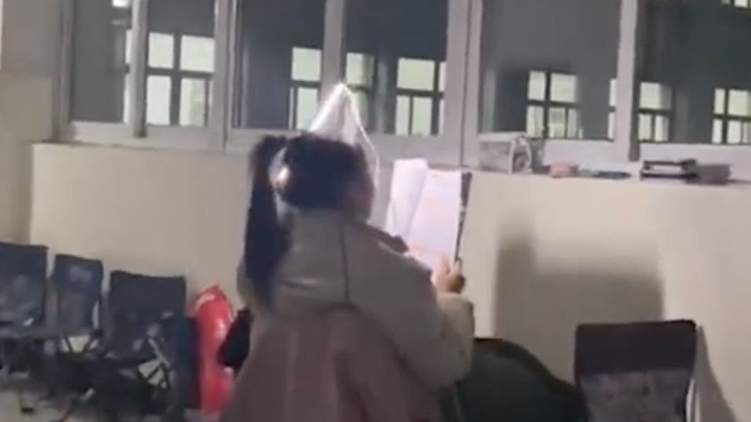 女同學把燈管插在頭上苦讀。(圖/翻攝自微博)