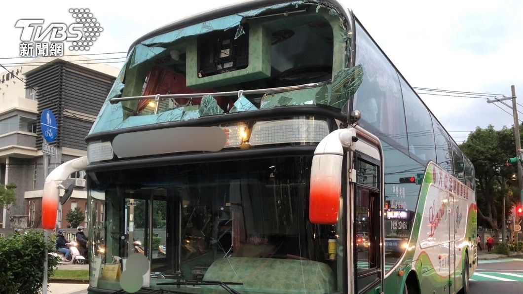 遊覽車撞斷限高架,上風擋風玻璃破了個大洞。(圖/警方提供)
