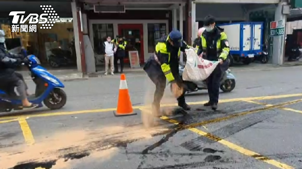 警方在路口灑木屑粉,防止汽機車滑倒。(圖/TVBS)