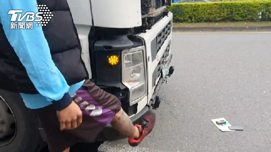 肇事的貨車駕駛用腳比劃,稱機車在他的右前方,視線死角根本沒看到才撞上去。(圖/TVBS)