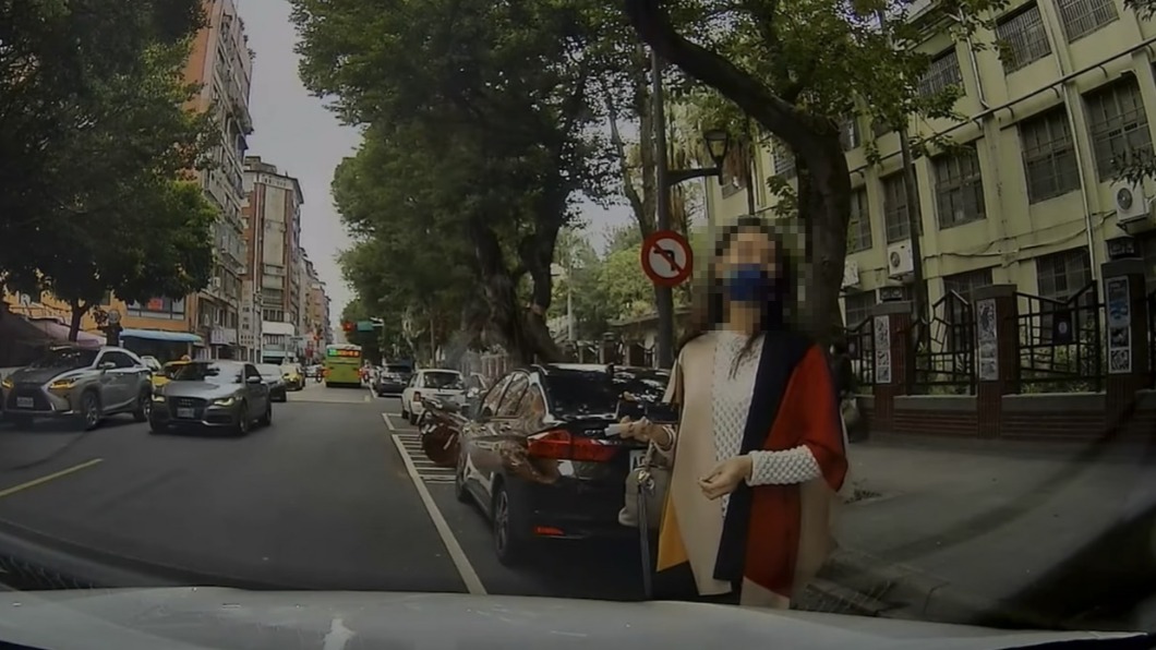 婦人站在白車車前。(圖/Facebook八卦村 - 行車紀錄器影片上傳中心)