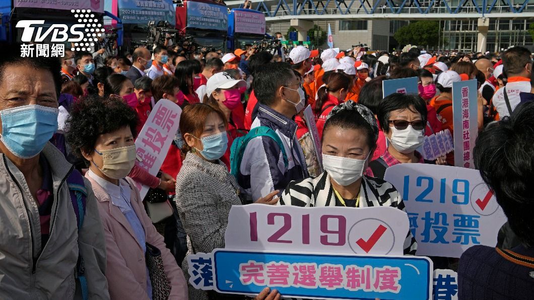 親北京支持者手持標語，呼籲民眾參與投票。（圖／達志影像美聯社）