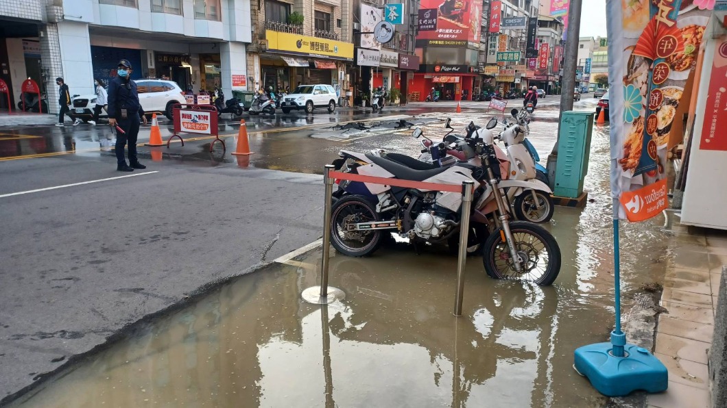 自來水爆管,柏油路龜裂、大量泥水溢出造成積水,警方到場交管。(圖/翻攝自記者爆料網)
