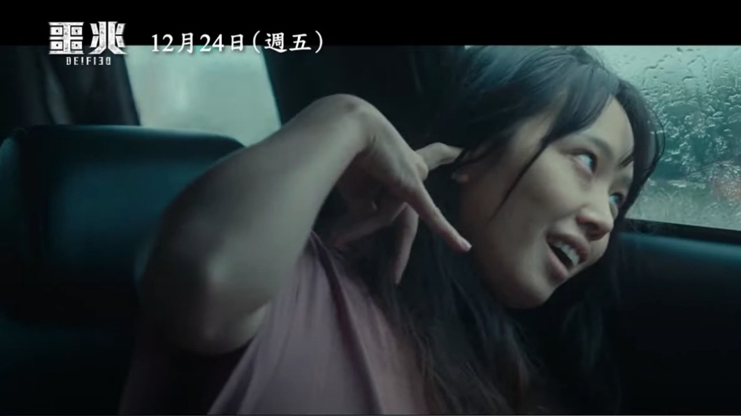 女性翻白眼邪笑並將手指插入耳朵的中邪畫面。(圖/翻攝自YouTube)