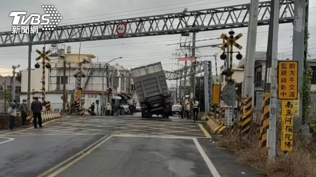 貨櫃車撞歪限高門,卡在平交道上。(圖/TVBS)