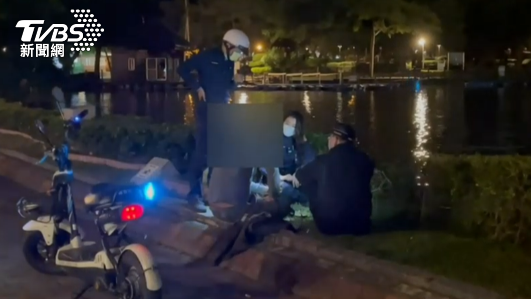 幾名員警坐在湖岸旁的草皮上,聽葛男傾吐心事。(圖/警方提供)