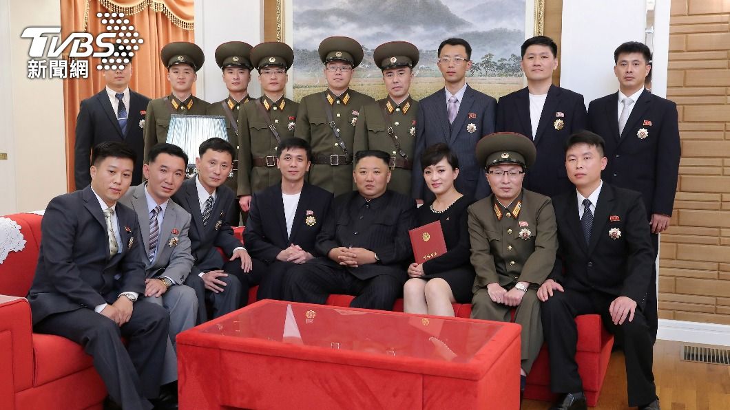 歌手金玉珠(右)與金正恩以及眾高官們合照。(圖/達志影像路透社)
