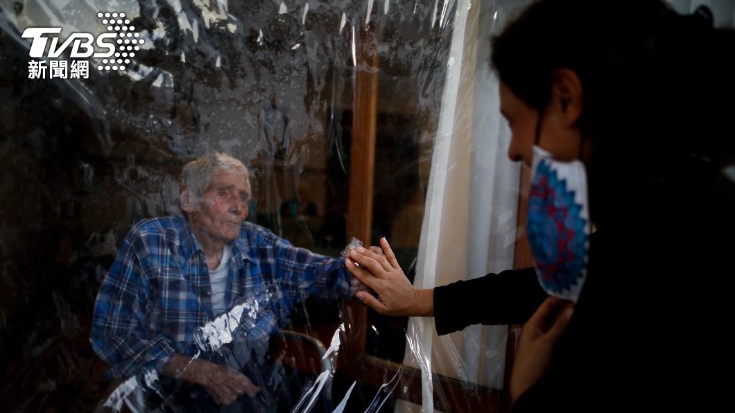 阿根廷一名86歲的老先生住在安養院,疫情期間只能隔著塑膠布與親人見面。(圖/達志影像美聯社)