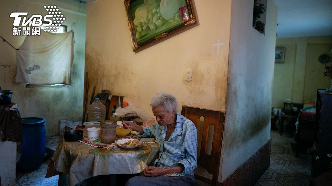 委內瑞拉一名88歲的老太太在疫情期間無法外出,獨自一人在家用餐。(圖/達志影像美聯社)