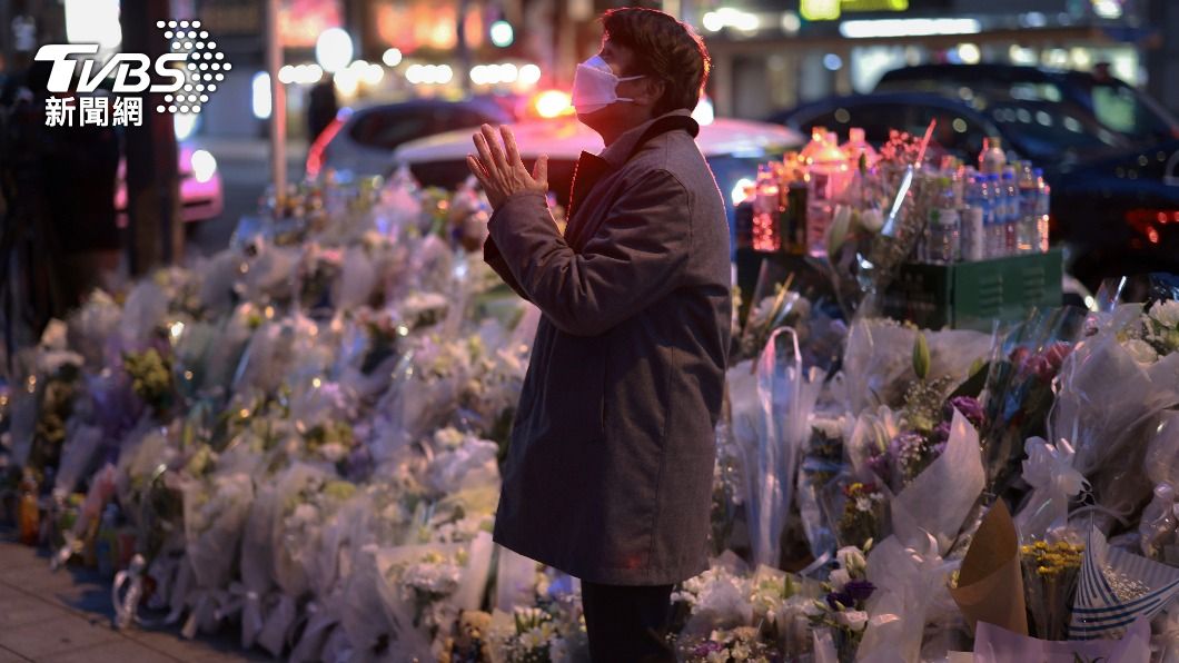 民眾於現場獻花,雙手合十向罹難者致意。(圖/達志影像美聯社)