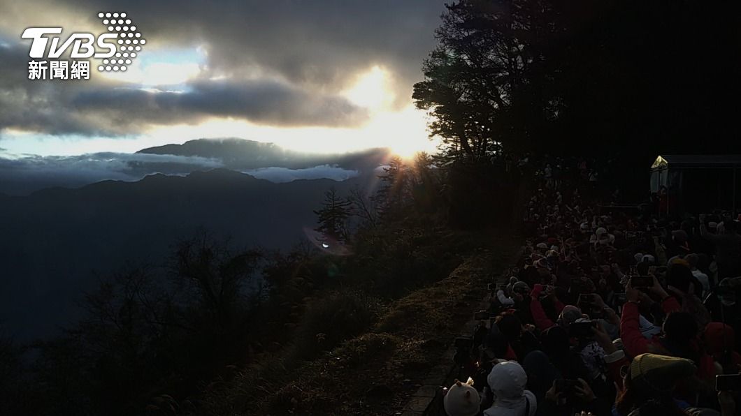 曙光從些許積雪的玉山群峰間躍出,遊客驚呼聲此起彼落。(圖/中央社)