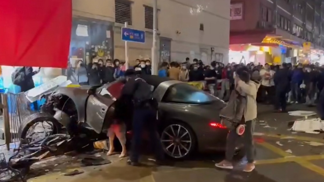 涉事黑色保時捷撞向行人路,撞毀鐵欄及路牌。(圖/翻攝自香港自由行加加微博)