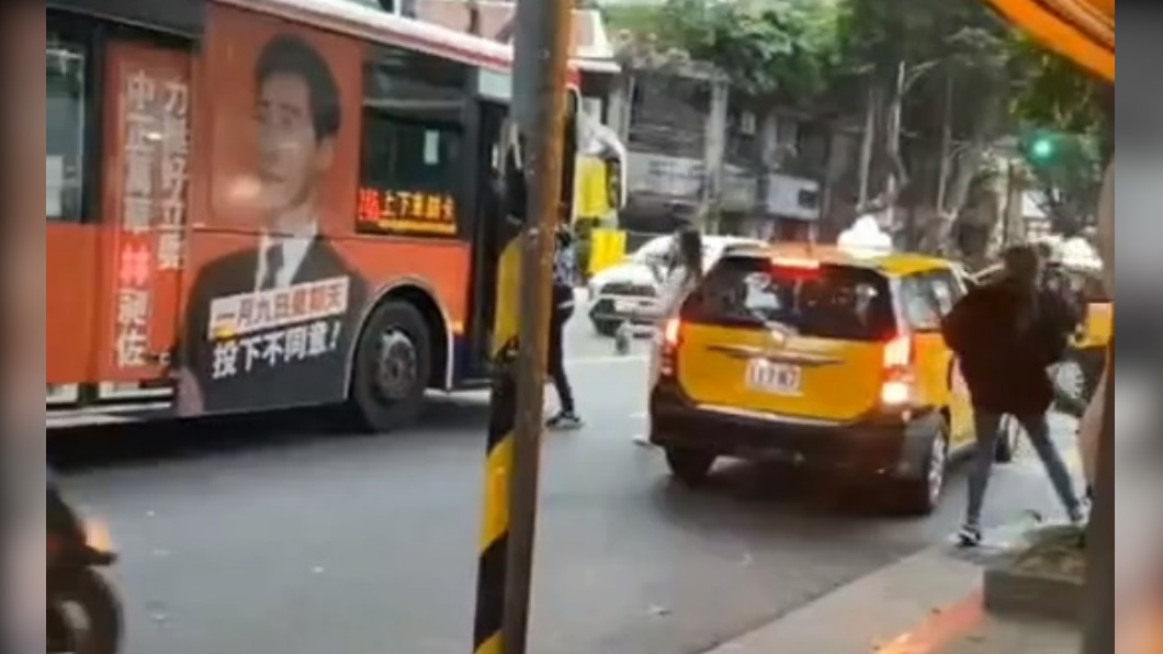 酒客在路口攔計程車但擋住公車行駛方向。(圖/翻攝記者爆料網)