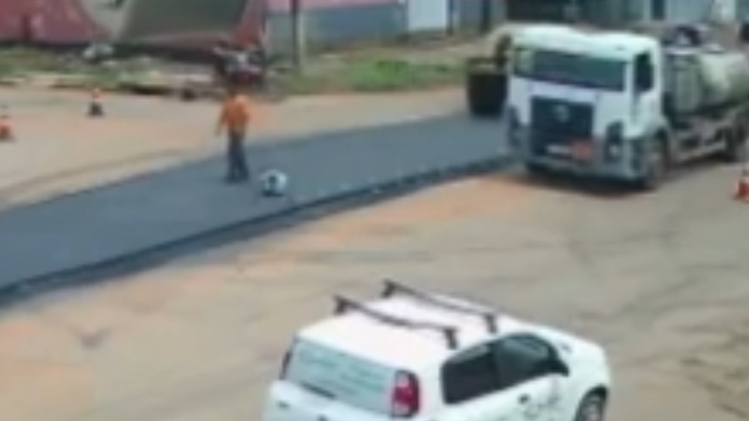 奧利維拉原本站在路上,完全沒發現後方的壓路機朝他直駛而來。(圖/翻攝自g1.globo)