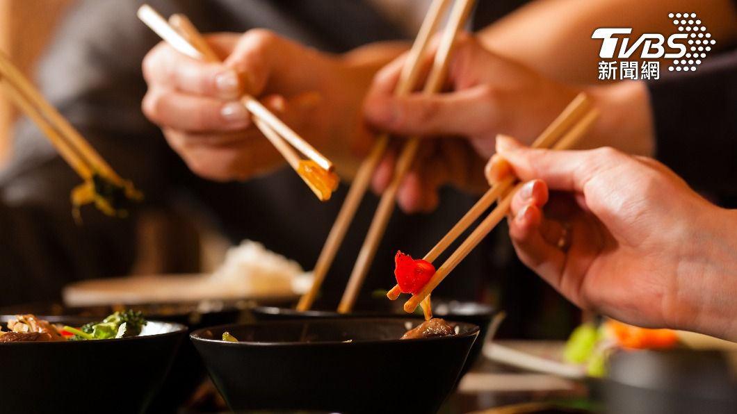 吃飯時越過他人的筷子夾菜是餐桌大忌。（示意圖／shutterstock達志影像）