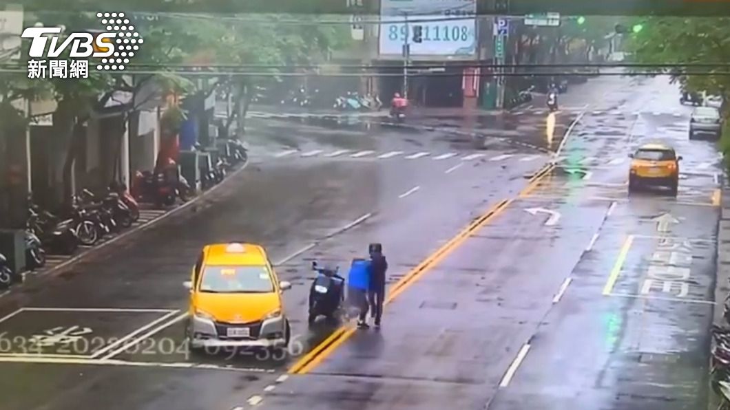 小黃駕駛跟機車騎士在馬路中間一路扭打到騎樓旁邊。 圖/TVBS