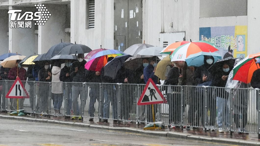 大量民眾冒雨排隊等待篩檢。(圖/達志影像路透社)