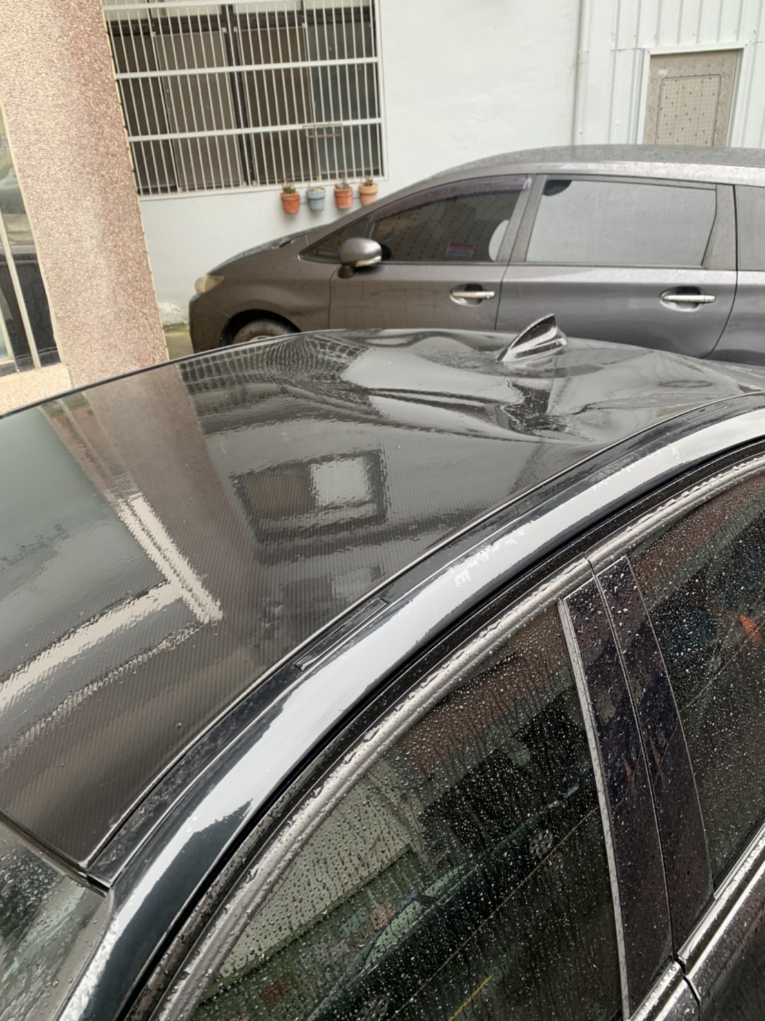 新竹風太大,鐵皮砸中路旁轎車,車頂凹陷一個洞。(圖/讀者提供)