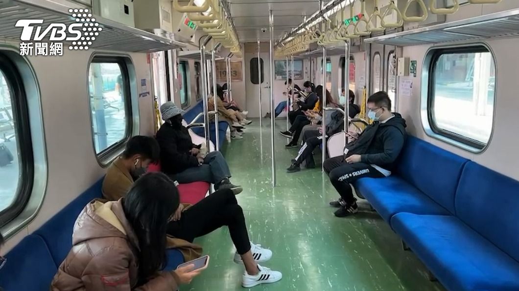 乘客坐在車廂內滑手機。(圖/TVBS)