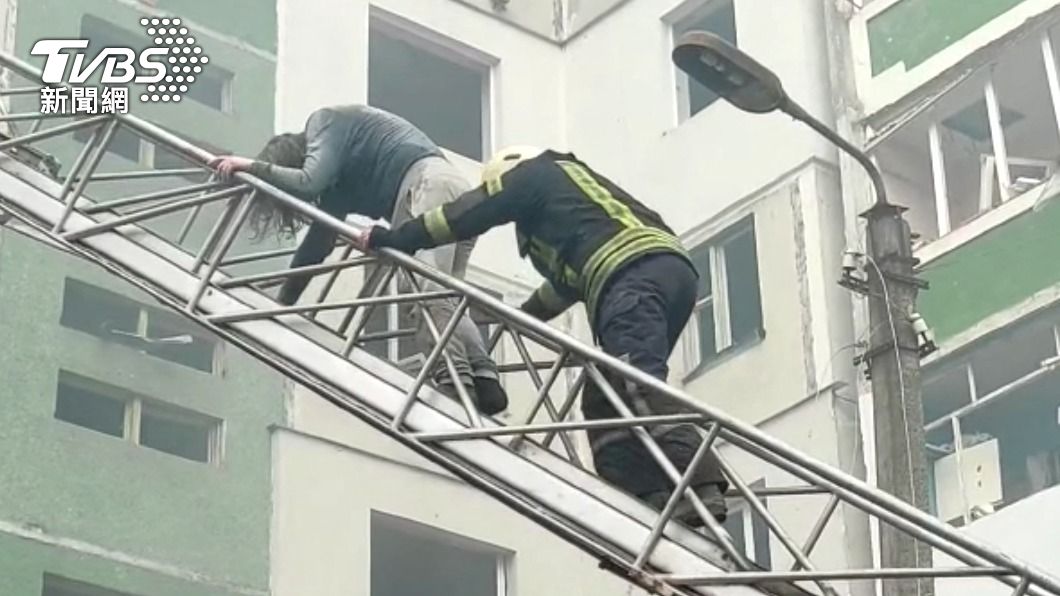 消防人員救出受困公寓民眾。(圖/達志影像路透社)