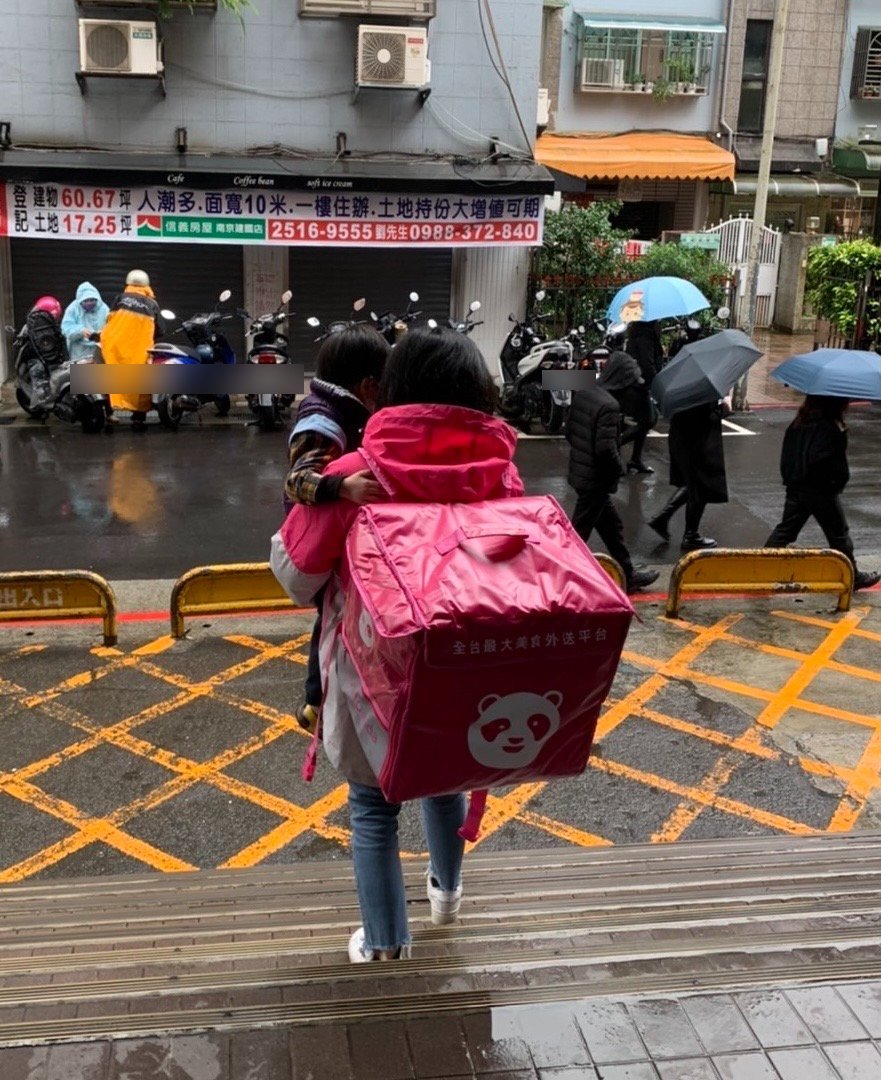 外送媽冒著雨勢抱孩子跑單。(圖/翻攝自爆廢公社二館)