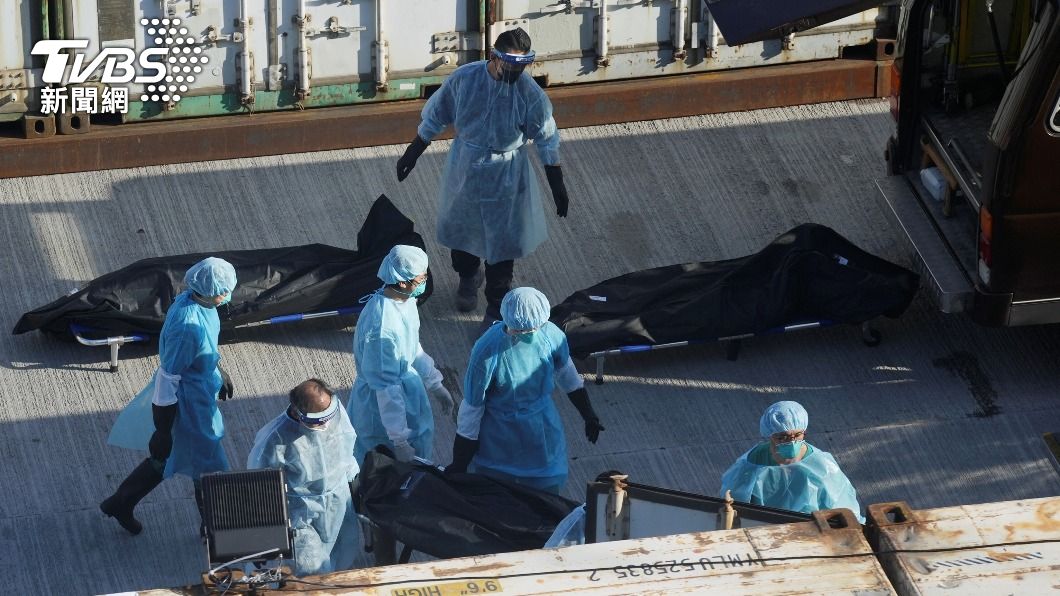 香港停屍間不足，工作人員穿著防護醫將染疫病歿者遺體搬至大型冷藏庫。（圖／達志影像路透社）