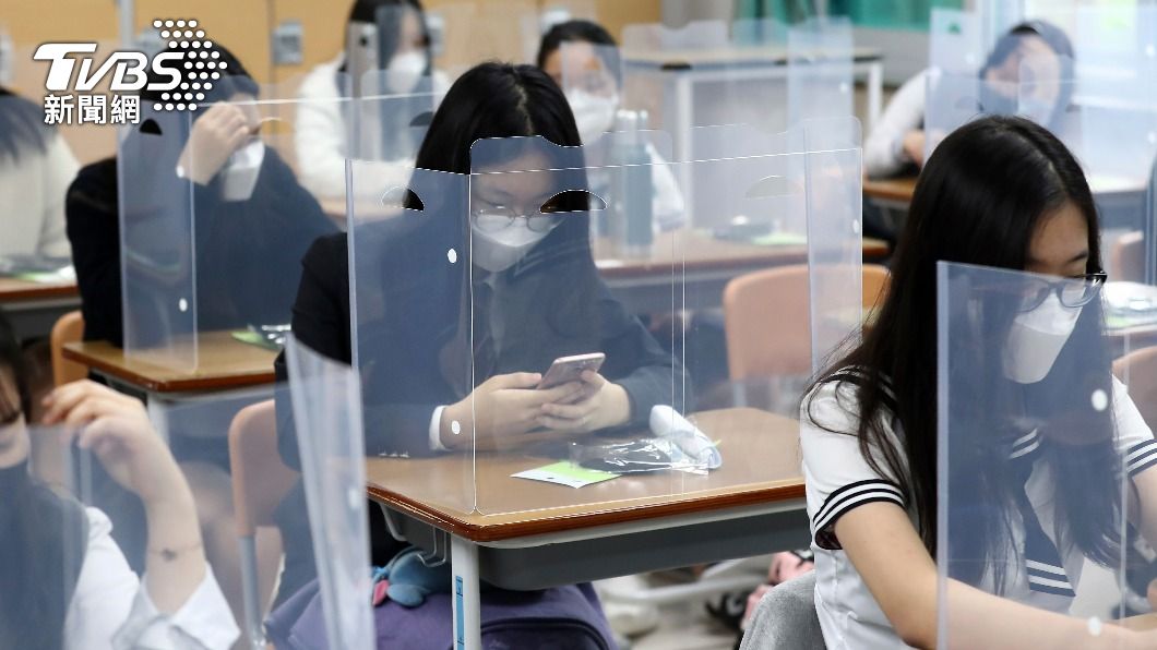 學生座位上置有塑膠隔板,每個人都戴著口罩。(圖/達志影像美聯社)