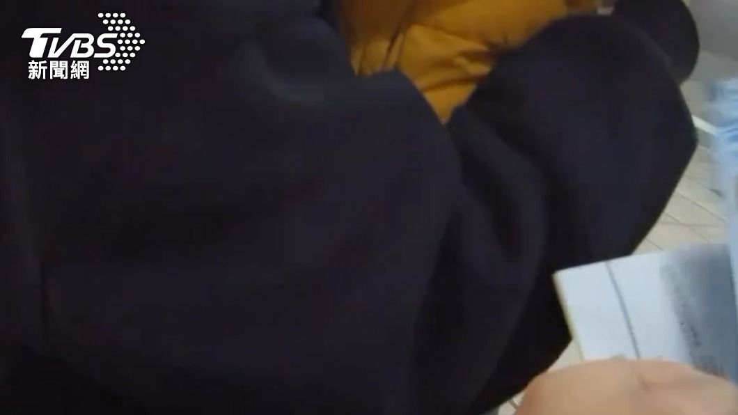 員警一邊抱著小孩,一邊從才藝班的資訊中找到爸爸。(圖/TVBS)